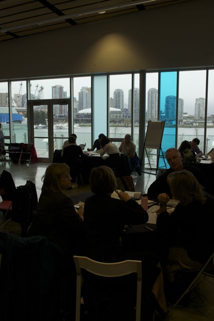 a group of people sitting around a table looking out the window