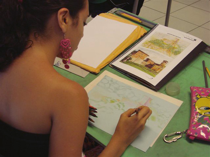 a woman in a black dress writing on a notebook