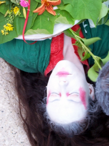 a woman lies down next to her hair and has an upside down doll