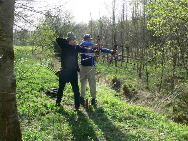 one man and woman are holding bows and aiming