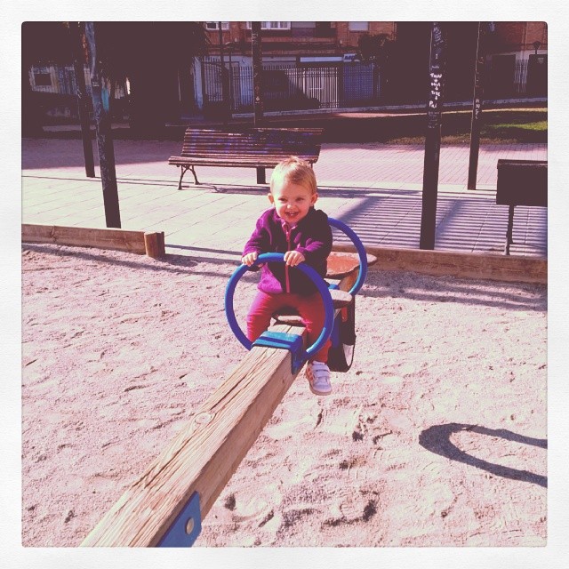 a baby playing on a wooden playground