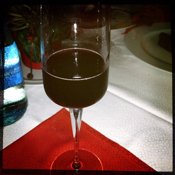 a wine glass with some red liquid in it