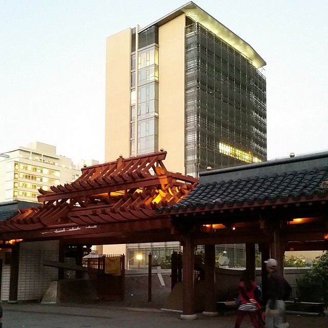 an asian structure in front of tall buildings