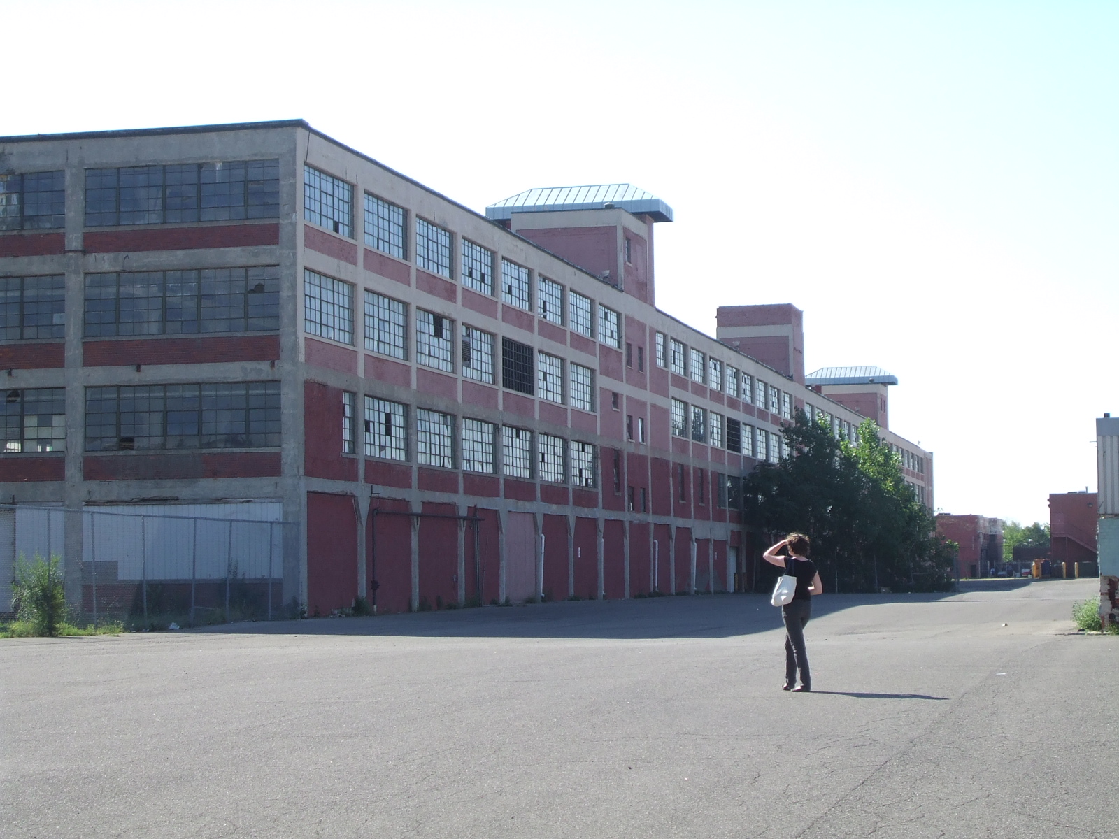 a person standing on a city street near an empty parking lot