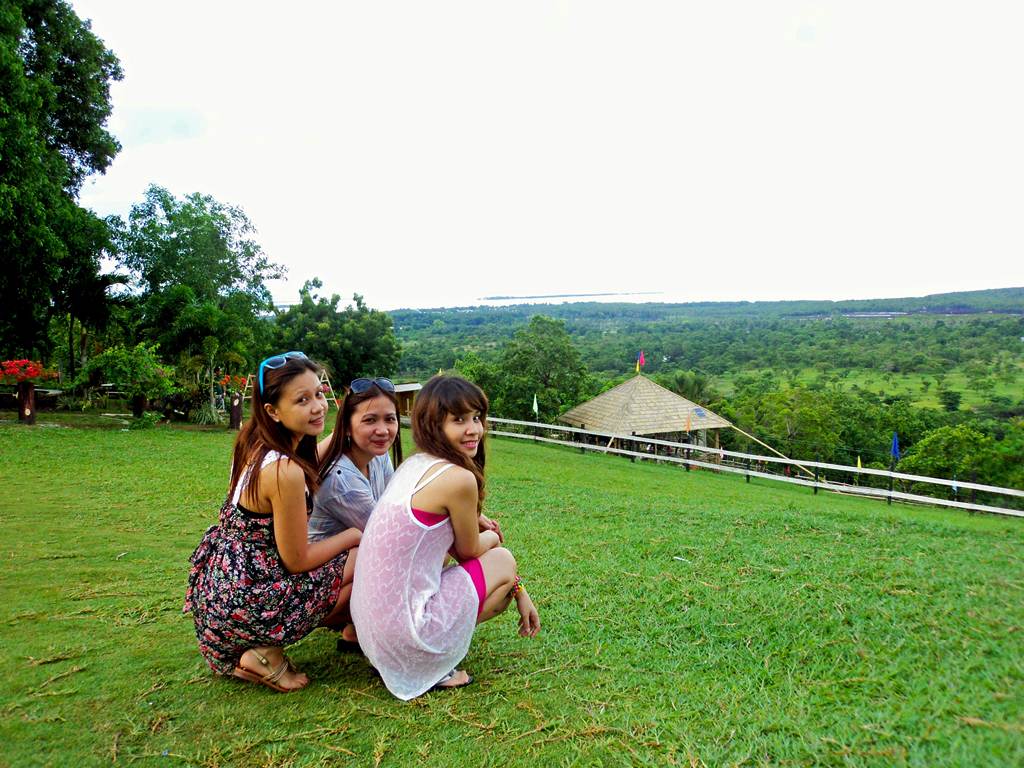 three girls pose for the camera on a hill