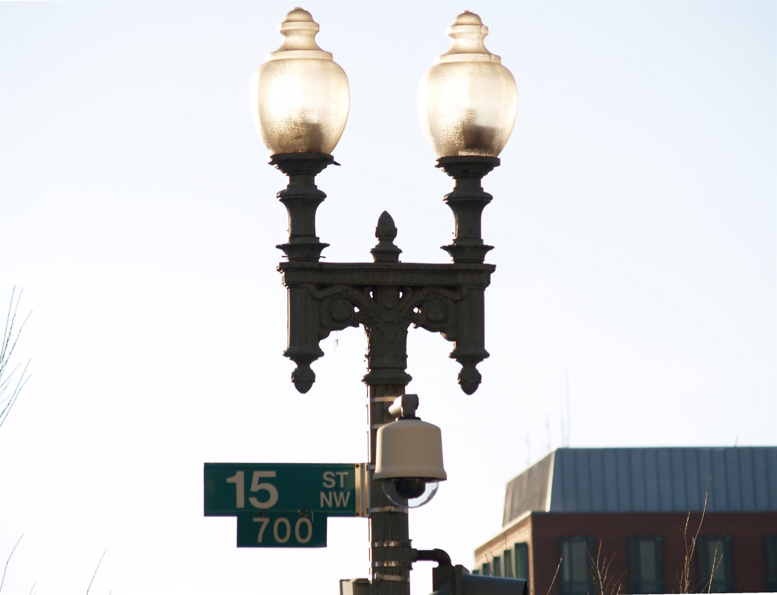 there is a street light and street sign on the corner of street