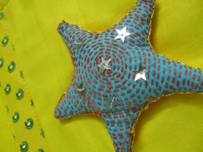 a starfish ornament hanging on a yellow cloth