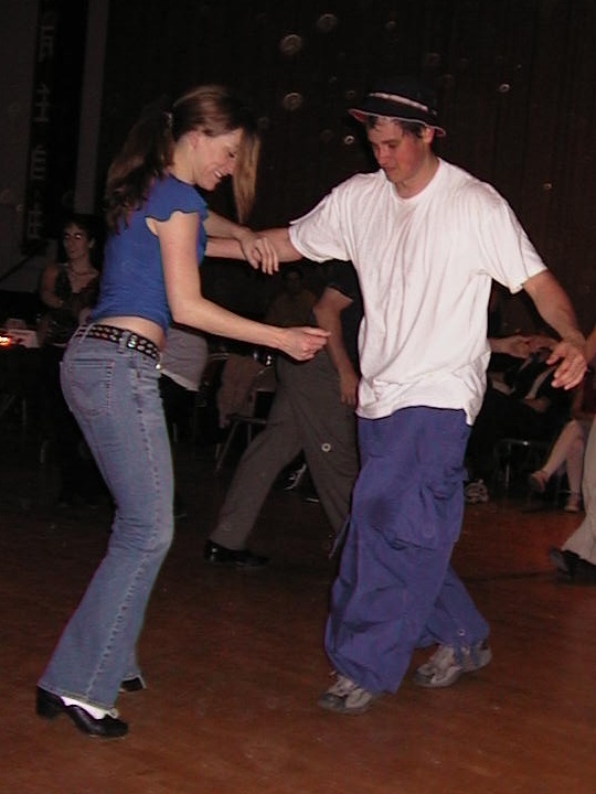 a man and a woman doing dancing on a wooden floor