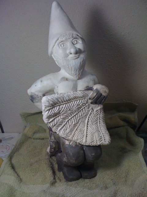 an older white gnome figurine holding a bag
