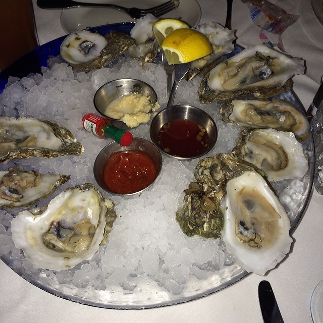 oysters are on the ice and some sauce on a tray