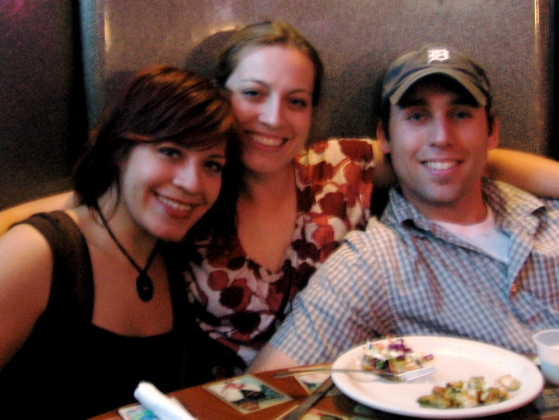 two adults and a child sitting around a table at a restaurant