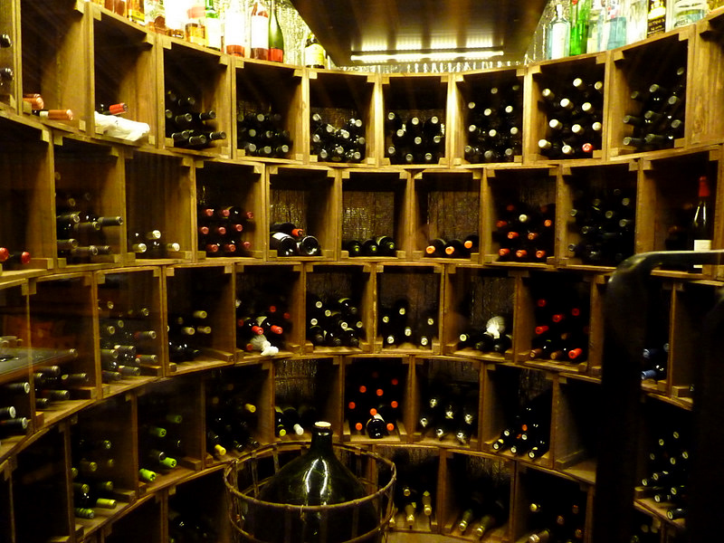 an enormous amount of bottles are stacked on one shelf