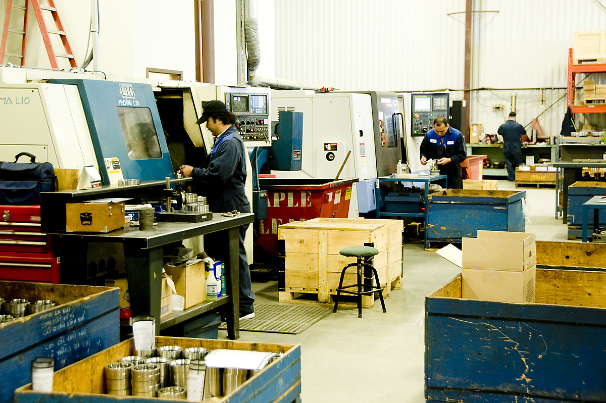 the man is working inside of an industrial machine shop