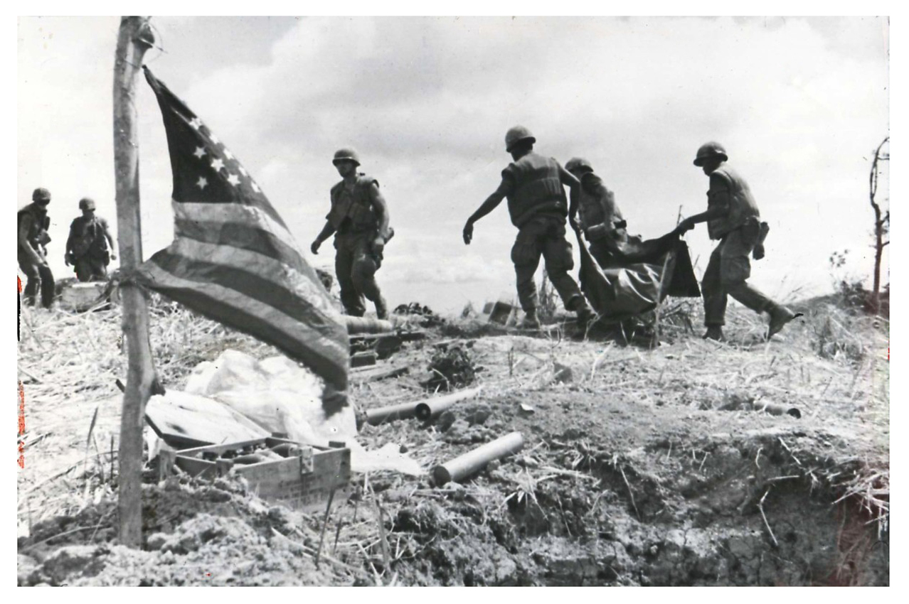 black and white pograph of military men on hill with an american flag