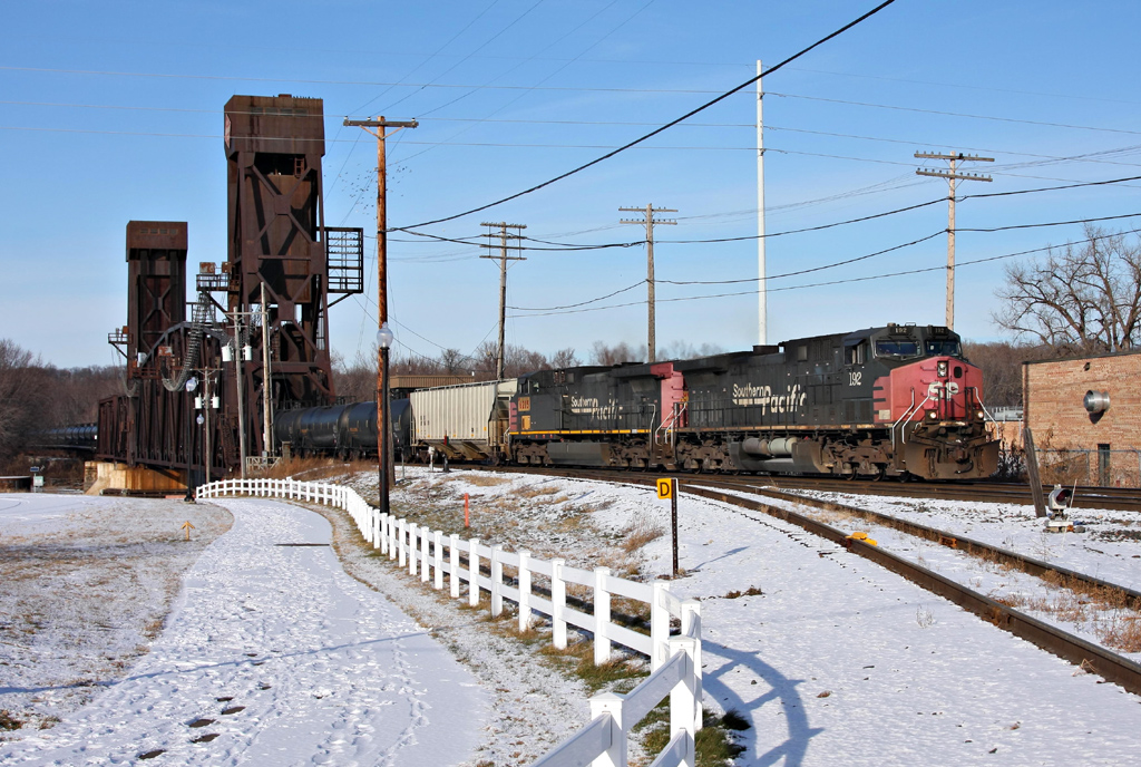 a freight train traveling down the tracks during the day