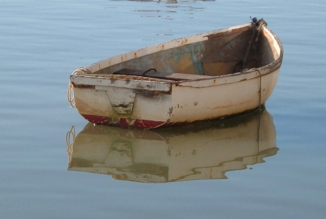 an old boat with water and its reflections