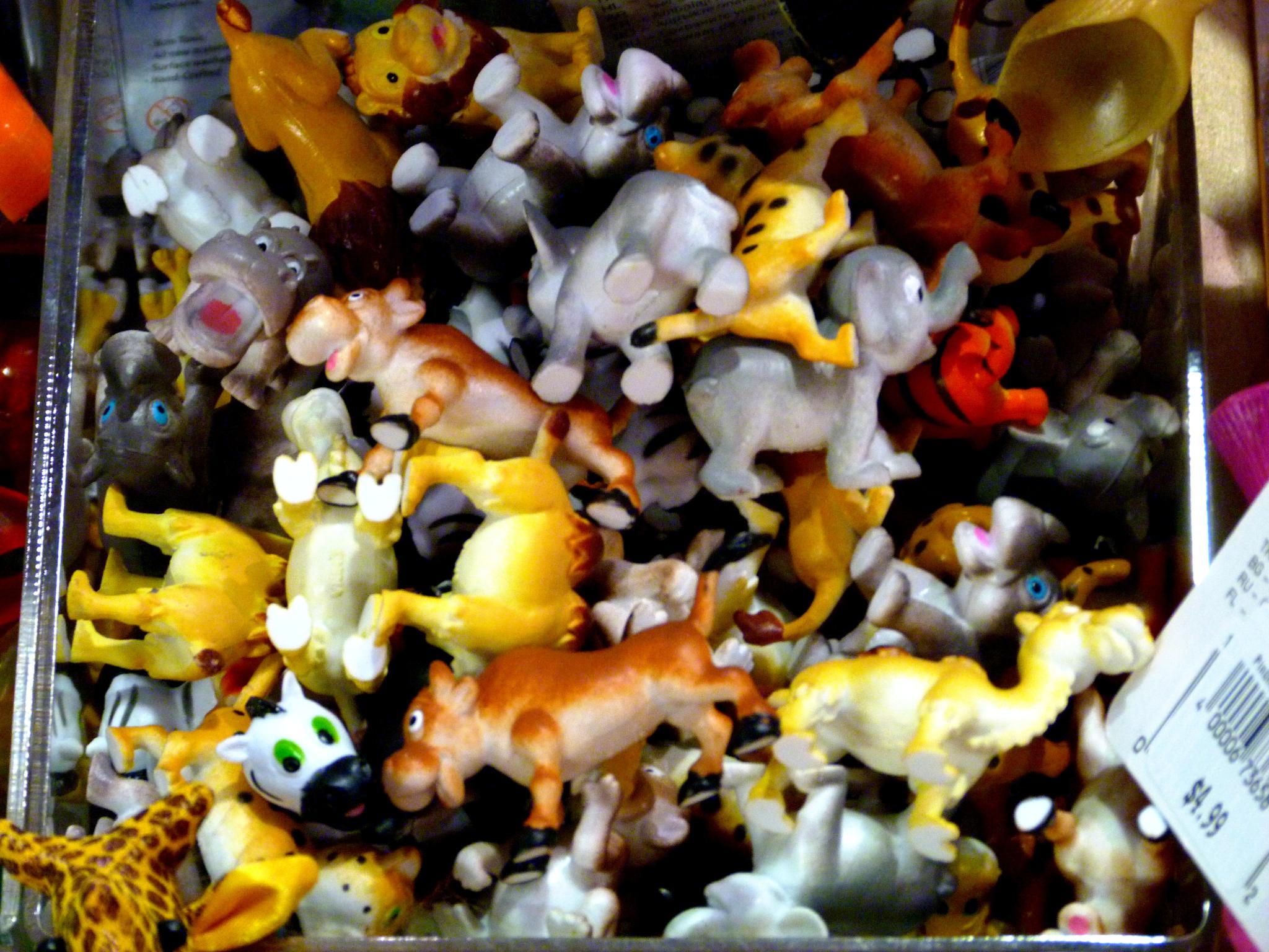 there are many small plastic toy animals in this container
