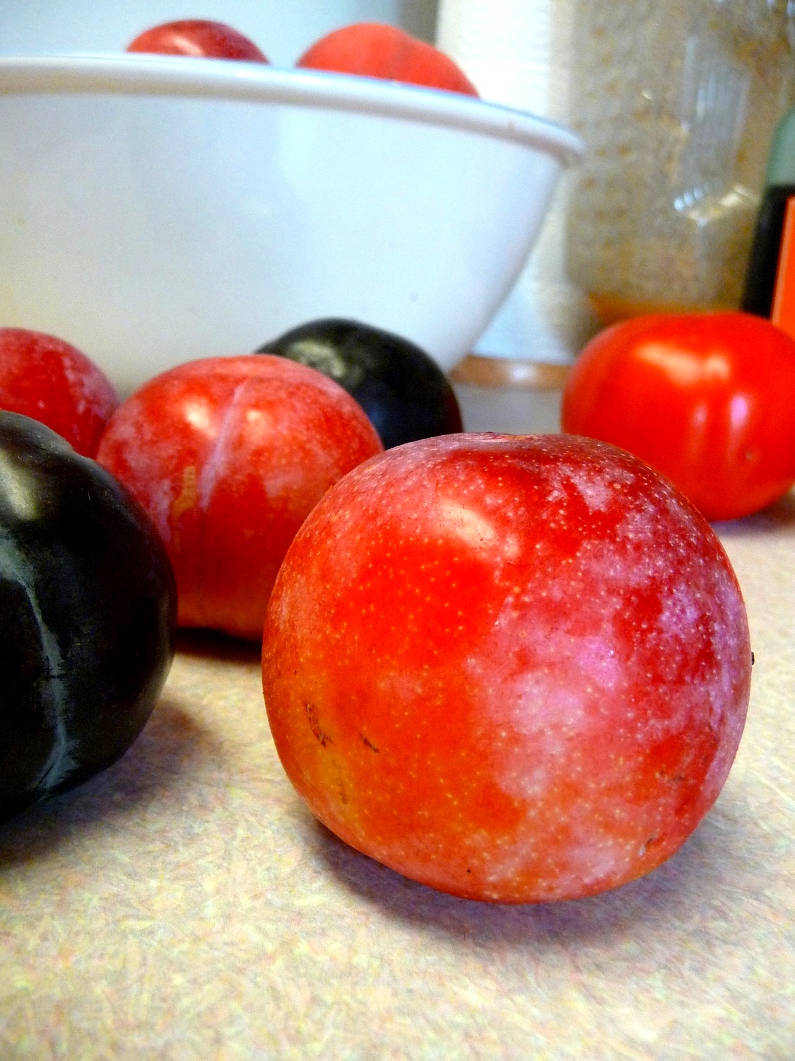 an orange and an eggplant sitting next to each other