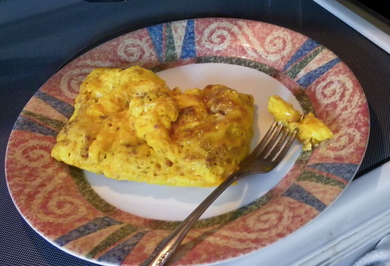 a pink and blue plate with a fork on it