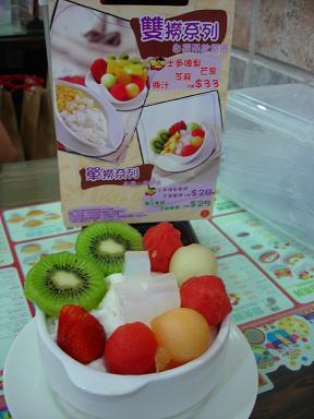 fresh fruit is in a white bowl next to the menu
