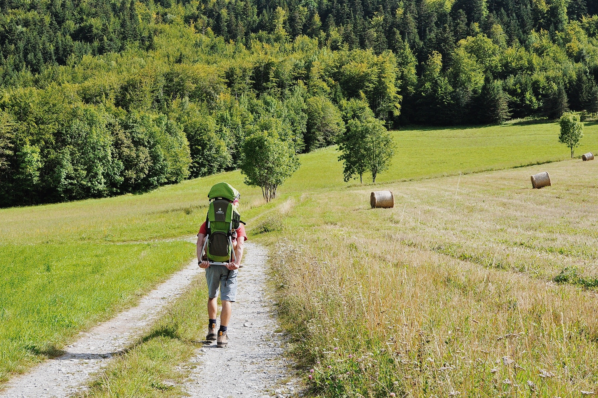 a person on a dirt path with a grass umbrella