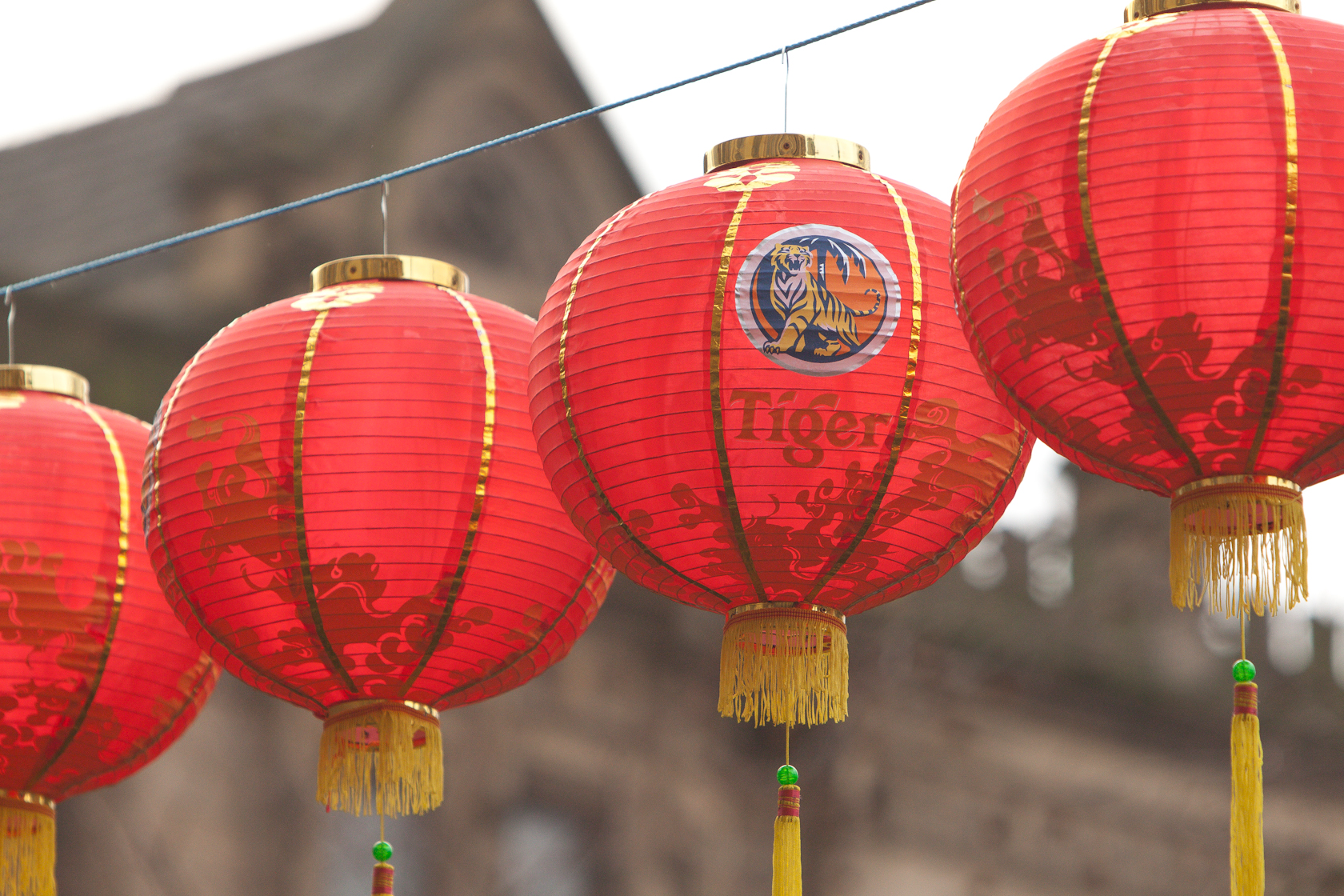 five red chinese lanterns hanging from wires