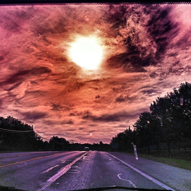 a cloudy sunset as seen through the windshield