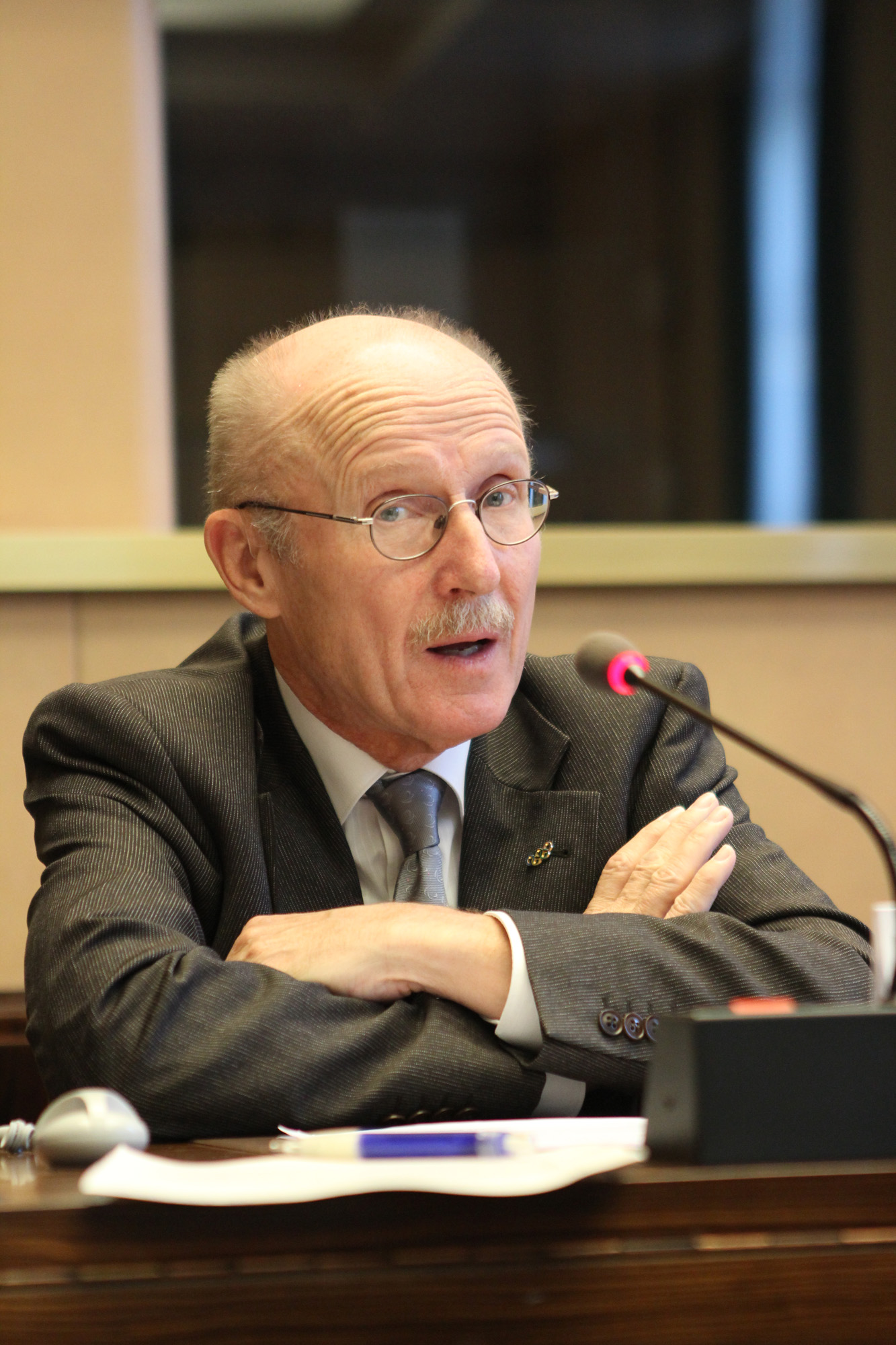 a older man sitting in front of a microphone