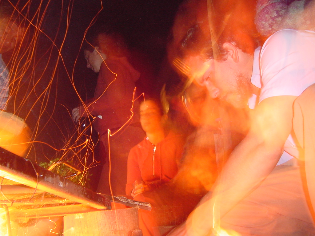 two guys sitting around with bright lighting in their hands