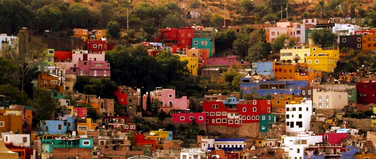 the colorful buildings of a city on the hillside