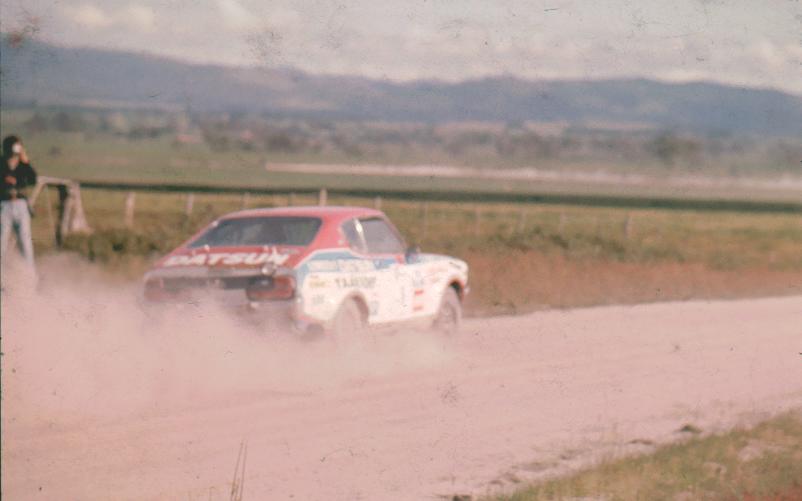 a race car with dirt driving along a dirt road