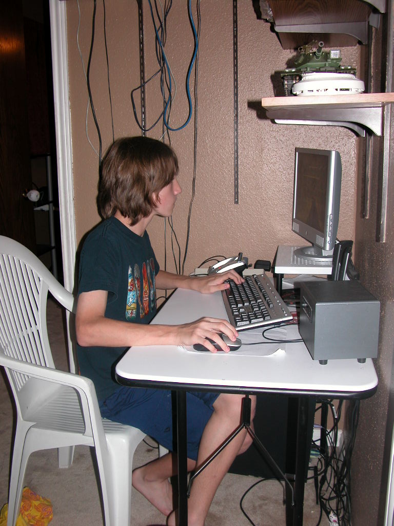a boy is sitting in front of a computer at his desk