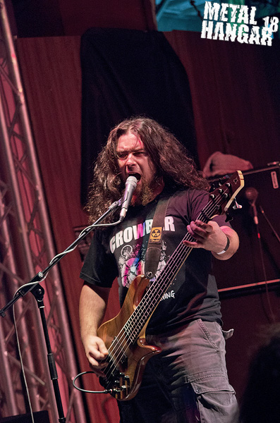 a man with long hair is playing a bass
