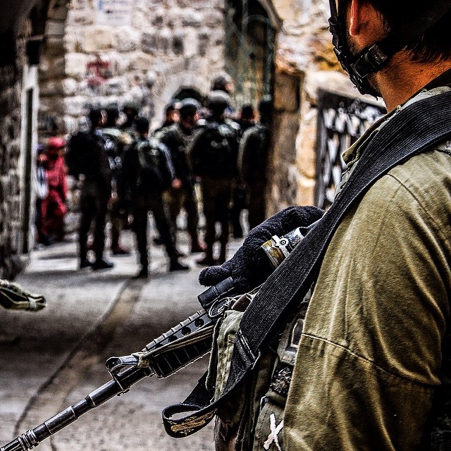 a man is holding a gun with other soldiers standing in the background