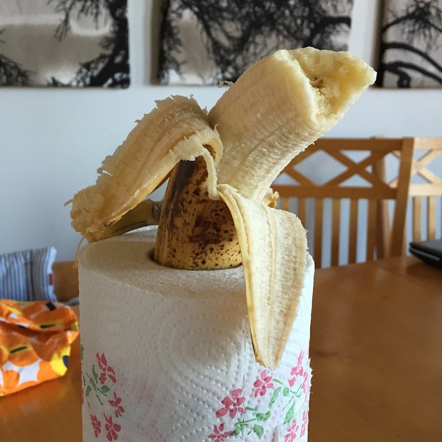 a partially eaten banana on top of a toilet paper roll