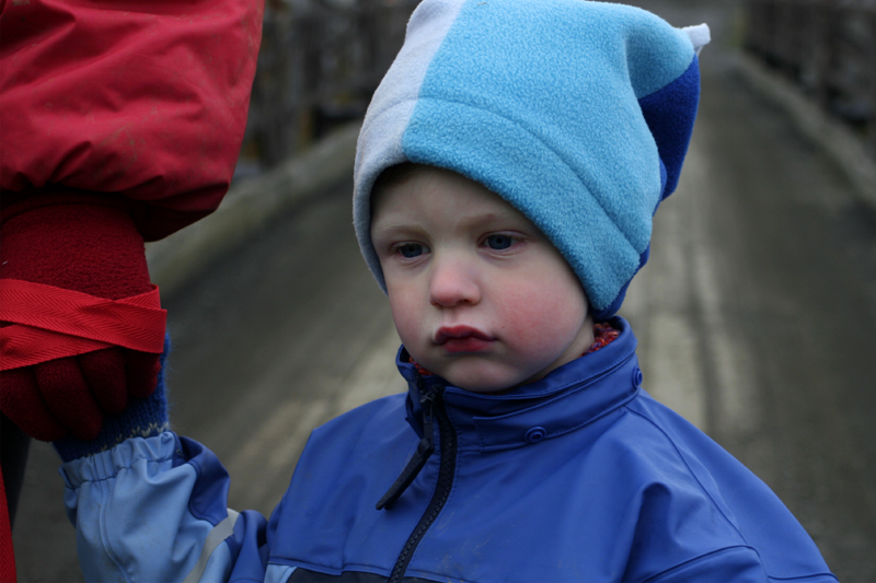 a  in blue jacket holding on to a piece of cloth