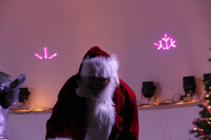 a man dressed as santa clause standing in front of a window