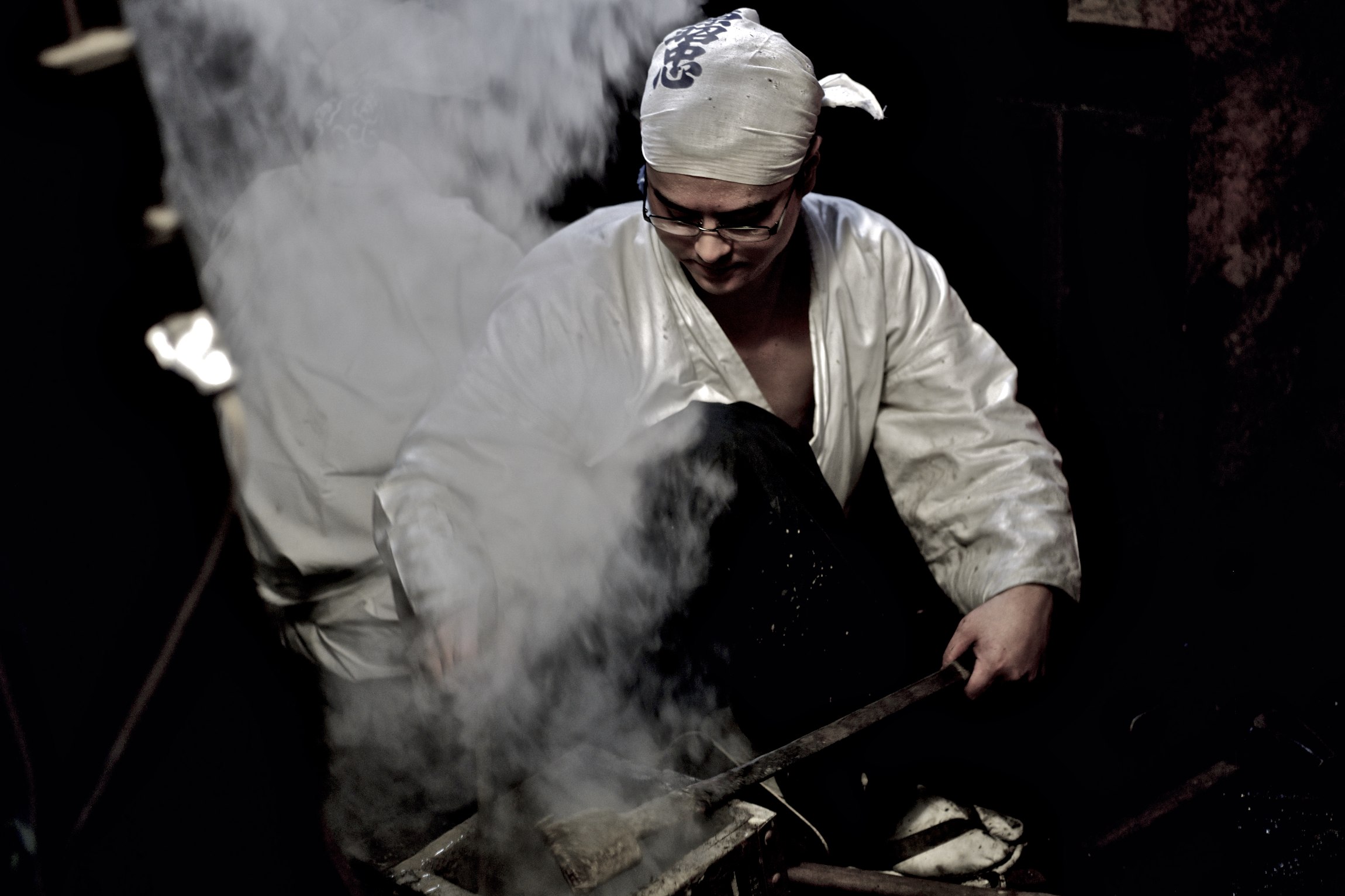 the man is stirring up the food in the wok