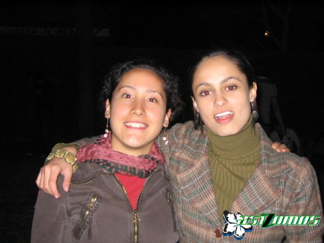 two smiling young women in their jackets at night