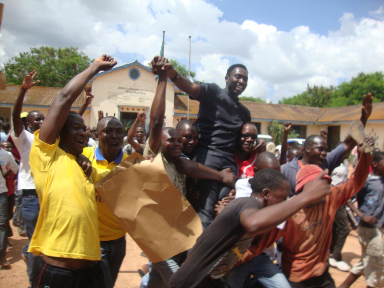 people holding up items and a man wearing a black shirt