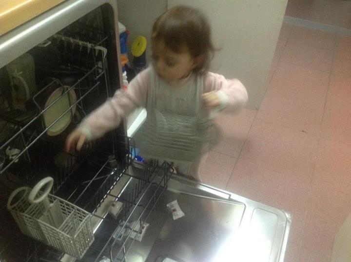 a small girl is looking into the oven