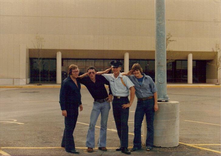 five people stand in a parking lot