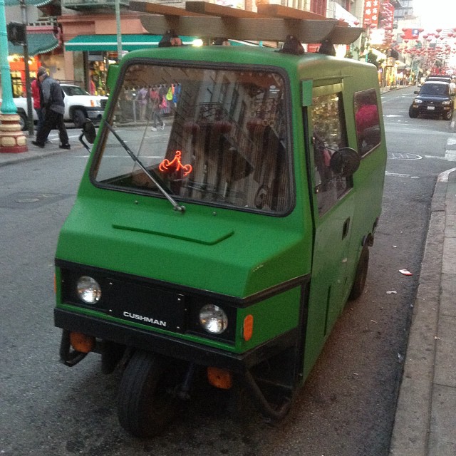 the small green truck has a long, slanted roof