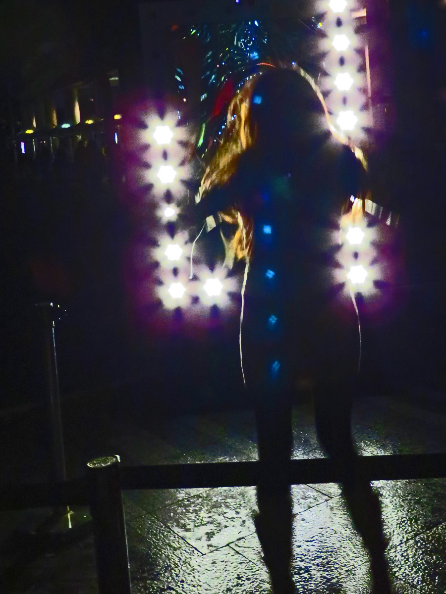 a woman with a lighted umbrella in the dark