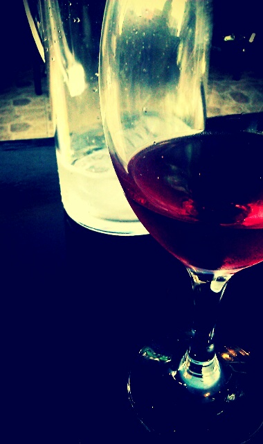 a glass of red wine sits in front of another glass