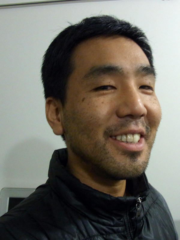 a man smiling with a large tooth brush in his mouth