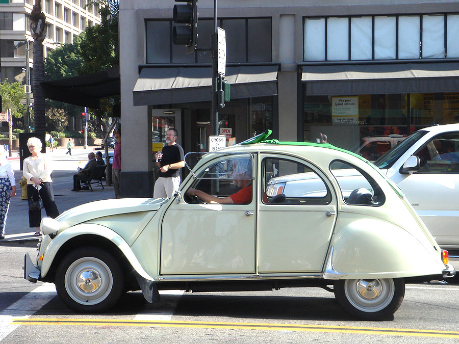 an old car is driving down the street