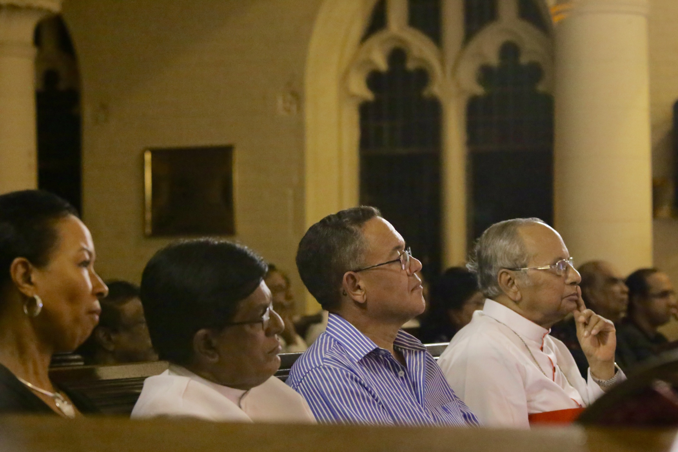 a group of people sit side by side and one man is looking up