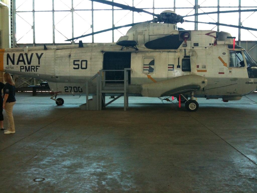 the military helicopter is parked inside the hangar