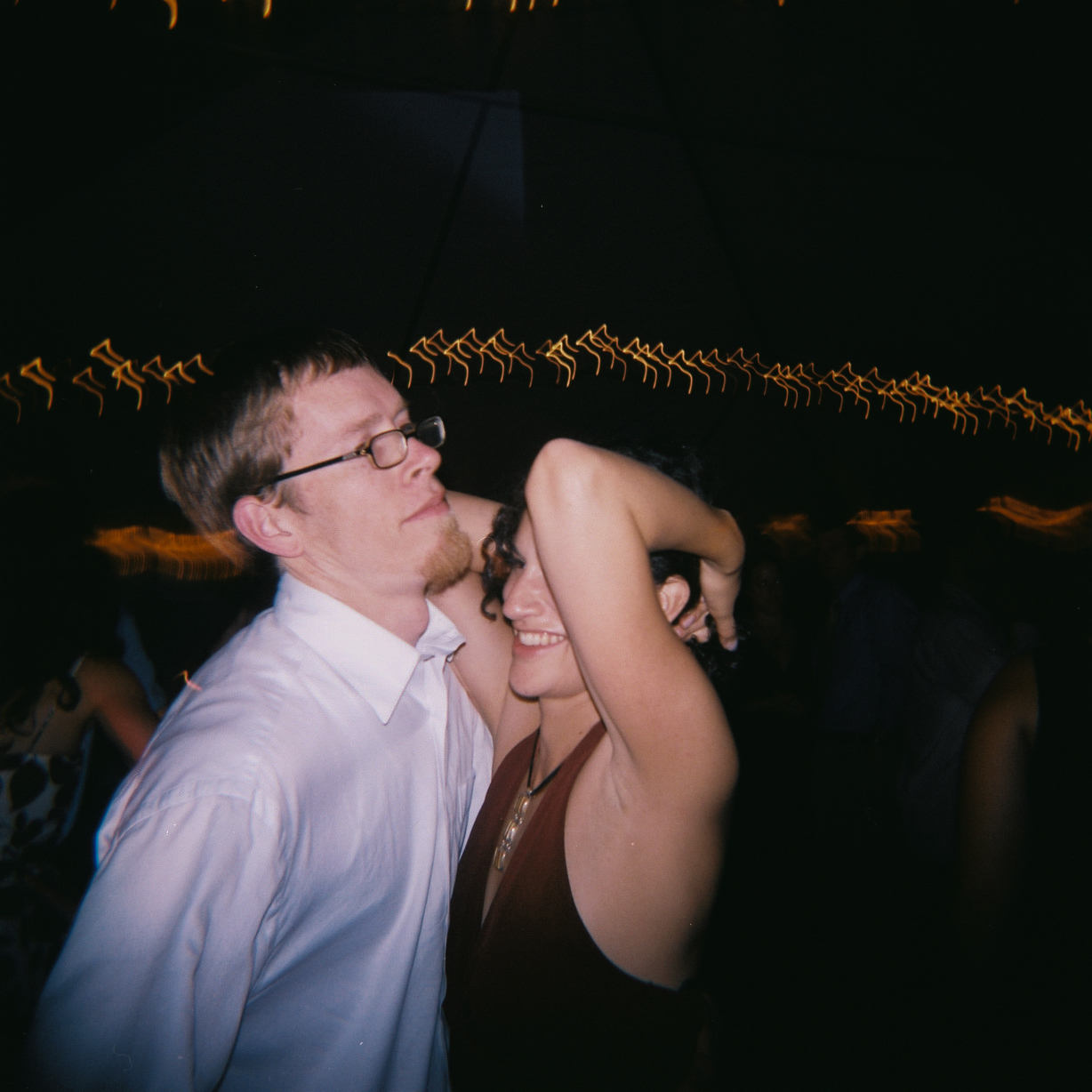 a man and woman dancing at an outdoor party
